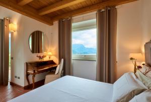 a bedroom with a bed and a desk and a window at Villa Maria Laura in Lierna +25 photos