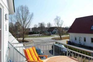 a balcony with two chairs and a table and a house at Fewo Dat Ole_ZECH in Ostseebad Karlshagen