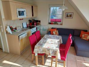 a kitchen and dining room with a table and red chairs at Fewo Dat Ole_ZECH in Ostseebad Karlshagen