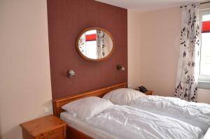a bedroom with a bed with a mirror on the wall at Ferienwohnung Maigloeckchen 05 str in Karlshagen +5 photos