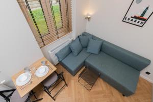 a living room with a couch and a table at Nad Motlawa Apartamenty Seredynskiego by Renters in Gdańsk