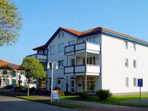 a large white building on the side of a street at Ferienwohnung Maigloeckchen 05 str in Karlshagen