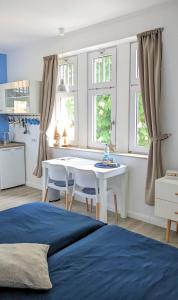ヴェルニゲローデにあるGoethes liebste Bettenのベッドルーム1室(ベッド1台、白いテーブル、窓付)