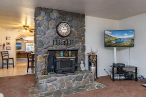 a living room with a stone fireplace with a clock at Apache Adventures in South Lake Tahoe
