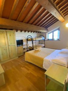 a bedroom with two beds in a room with wooden floors at Tenuta La Lupa in Castellina Marittima