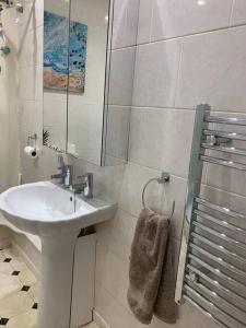 a white bathroom with a sink and a shower at Bougainvillea in Ventnor