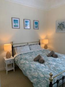 a bedroom with a bed with two lamps on it at Bougainvillea in Ventnor