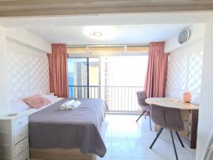 sypialnia z łóżkiem i stołem oraz balkonem w obiekcie Agua Mundo studio w mieście Benidorm +33 zdjęcia