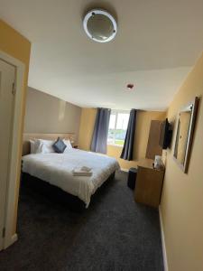 a hotel room with a large bed and a window at Tinapa Suites in Manchester