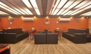 a waiting room with couches and chairs and a wall at Treebo Trend Mangalam in Kolkata