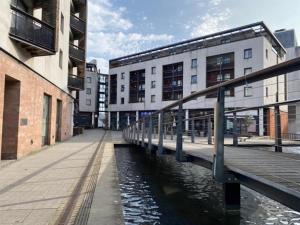 a bridge over a river in a city with buildings at Stunning Modern Coventry City Centre Apartment in Coventry