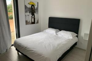1 dormitorio con 1 cama con sombrilla amarilla en Tramontana quiet place 7 min from beach swimming pool bbq en Calenzana