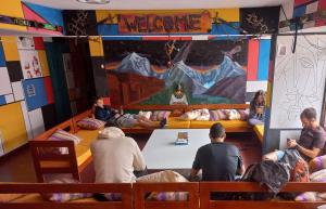 a group of people sitting around a table in a room at Big Mountain Hostel in Huaraz