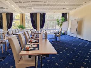 a conference room with long tables and chairs at CAREA Residenz Hotel Harzhöhe in Hahnenklee-Bockswiese
