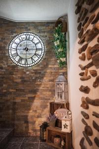 een grote klok op een bakstenen muur in een kamer bij House Proctor in Stoykite