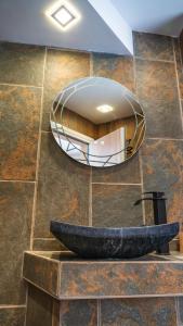 a bathroom with a round mirror on the wall at House Proctor in Stoykite