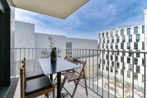 einen Balkon mit einem Tisch und Stühlen in der Unterkunft Appartement Glamour in Paris