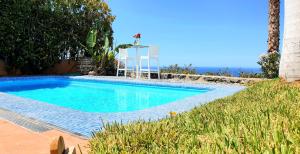 una piscina en un patio con el océano en el fondo en Exclusive Villa Golf Private Pool, en Adeje