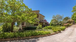 a stone house with a garden in front of a driveway at Villa Paola 6, Emma Villas in Gualdo Cattaneo