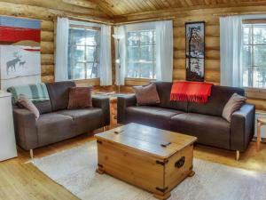 ein Wohnzimmer mit zwei Sofas und einem Couchtisch in der Unterkunft Holiday Home Vuosselin kuukkeli by Interhome in Virkkula