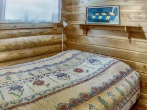 Bett in einem Blockhaus mit Fenster in der Unterkunft Holiday Home Vuosselin kuukkeli by Interhome in Virkkula