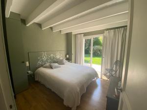 ヴァルボンヌにあるVilla de Mihaのベッドルーム(白いベッド1台、大きな窓付)
