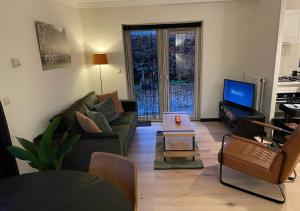 uma sala de estar com um sofá e uma televisão em Bed en Natuurhuisje em Laren