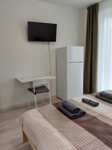 a room with two beds with a desk and a refrigerator at Arsenal House Budapest 1041 in Budapest