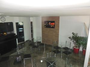 uma sala de jantar com cadeiras e mesas e um relógio em HOTEL QUALITY em Parauapebas