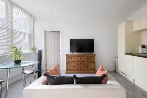 a living room with a white couch and a tv at Ipswich Town Centre - Apartment 7 in Ipswich