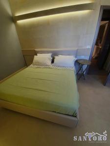 a bedroom with a bed with green sheets and pillows at Otranto casevacanza Elena in Otranto