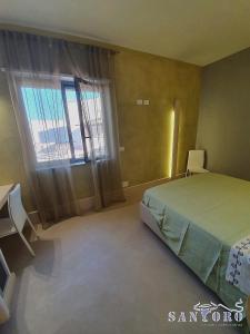 een slaapkamer met een bed en een groot raam bij Otranto casavacanza Elena in Otranto