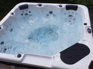 a jacuzzi tub with blue water in it at Holiday Home Al Fopp by Interhome in Masino