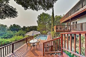 a deck with a table and an umbrella and a pool at Highland Oasis in Cloverdale