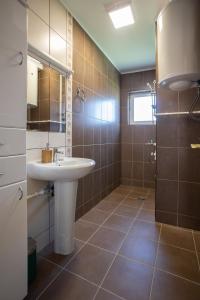ソコバニャにあるA Apartmaniの白い洗面台とシャワー付きのバスルーム +27枚の写真