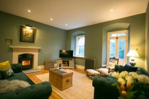 a living room with a couch and a fireplace at Glyn Y Coed, Mumbles in Newton