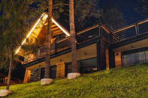 a house on a hill with a deck at night at Rezydencja Boutique SKI - 200m do Term Bania Odkryj Białkę in Białka Tatrzanska