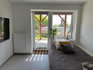 salon z kanapą i przesuwnymi szklanymi drzwiami w obiekcie Apartament Połaniecka 1B/2 w Zielonej Górze