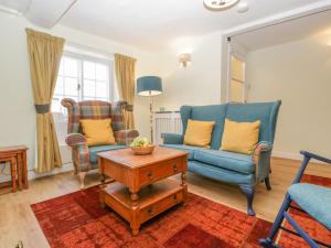 uma sala de estar com duas cadeiras e uma mesa em Bell Cottage em Dorchester