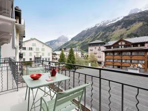 a balcony with a table and chairs and mountains at Studio Le Paccard-1 by Interhome in Chamonix