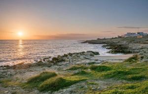 a sunset over the ocean with a rocky beach at Gallipoli Mancaversa Futura Vacanza Andrea in Marina di Mancaversa