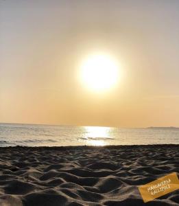 a beach with the sun rising over the ocean at Gallipoli Mancaversa Futura Vacanza Andrea in Marina di Mancaversa
