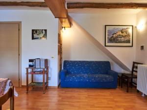 a living room with a blue couch and a staircase at Apartment Il Torrione-1 by Interhome in Claino +15 photos