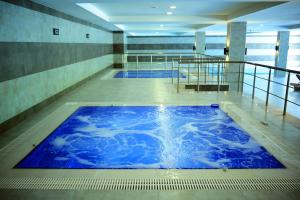 a large blue swimming pool in a building at Macara Lake Park in Quba