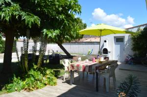 a table with a yellow umbrella on a patio at L'Acheneau in Marennes