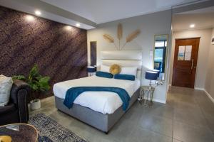 - une chambre avec un grand lit blanc et des oreillers bleus dans l'établissement Stay at The Point - Superb Studio Serenity, à Durban