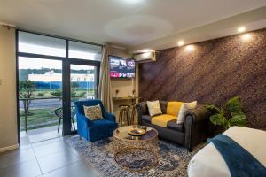 - un salon avec un canapé et une chaise dans l'établissement Stay at The Point - Superb Studio Serenity, à Durban