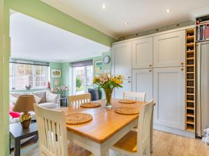 a kitchen and dining room with a wooden table and chairs at 38 Upton Towans in Hayle