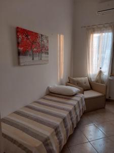 1 dormitorio con cama, sofá y ventana en Baciata Dal Sole Home en Monopoli