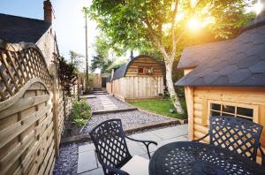 a backyard with two chairs and a fence at Luxury Mary's Croft with Swedish Hot tub and BBQ HUT in Shrewsbury